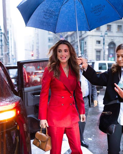 الملكة رانيا تحت المطر في انتظار عبور السيارات